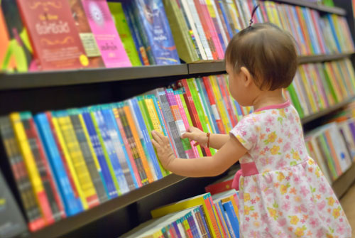 little girl in front of books